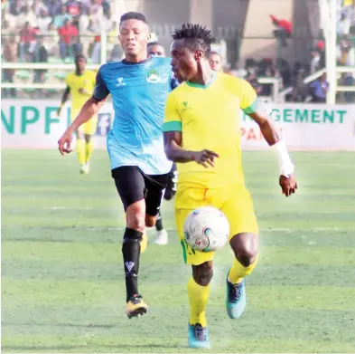  ??  ?? Kano Pillars marksman, Junior Lokosa (in front) shields the ball from Nasarawa United's Victor Okolo during their match at the Sani Abacha stadium Kano.