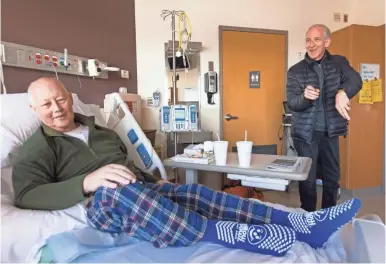  ?? MARK HOFFMAN/ USA TODAY NETWORK ?? Pulmonolog­ist Glenn Ragalie, right, says goodbye to hospice physician Bruce Wilson after a visit Jan. 16 at Froedtert Hospital in Wauwatosa, Wis. Wilson has end-stage pancreatic cancer.