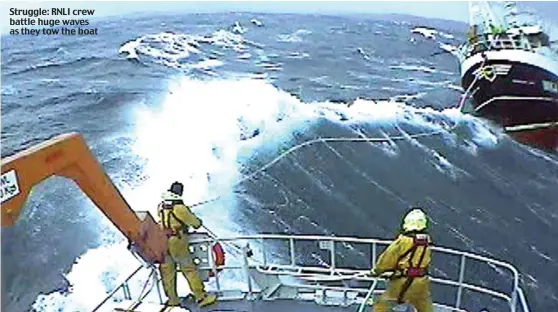  ??  ?? Struggle: RNLI crew battle huge waves as they tow the boat