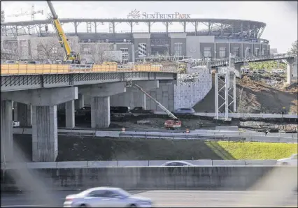  ?? BOB ANDRES / BANDRES@AJC.COM ?? Bridge constructi­on continues on Windy Ridge Parkway going across I-75 to SunTrust Park in Cobb County. One month before the first pitch at SunTrust Park, the Braves front office had demanded an additional $14 million from Cobb County taxpayers.