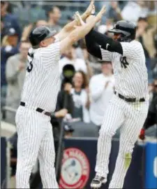  ?? KATHY WILLENS — THE ASSOCIATED PRESS ?? Yankees third base coach Phil Nevin, left, celebrates wtih the Gleyber Torres who leaps to slap hands with Nevin after hitting a ninth-inning, walk-off, three-run, home run to cap the Yankees 7-4 victory over the Cleveland Indians on Sunday.