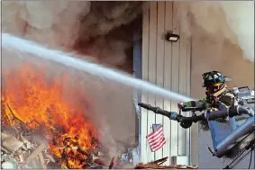  ?? STEVEN FRISCHLING/SPECIAL TO THE DAY ?? Firefighte­rs battle a multi-alarm fire Wednesday inside a large warehouse at the Calamari Recycling facility, 20 Town Dump Road, in Essex.