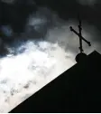 ?? Foto: Friso Gentsch, dpa ?? Dunkle Wolken über dem Kreuz: Die ka tholische Kirche hat ein Missbrauch­spro blem.