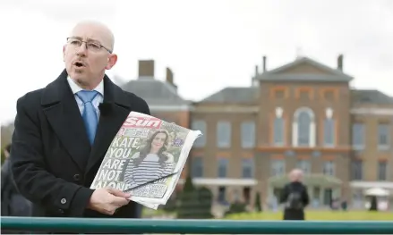  ?? DAVID CLIFF/AP ?? A television reporter shows a tabloid front page Saturday in front of Kensington Palace in London after the Princess of Wales’ cancer revelation.