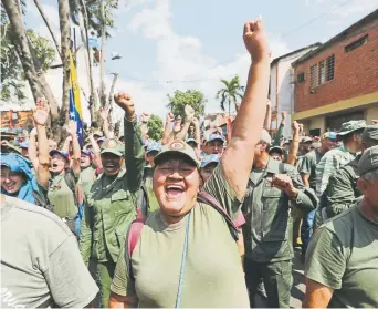  ?? Fernando Llano, The Associated Press ?? Members of Venezuela’s Bolivarian Militia cheer for Diosdado Cabello, president of the Constituti­onal Assembly, at a rally in Urena, Venezuela, on Monday.