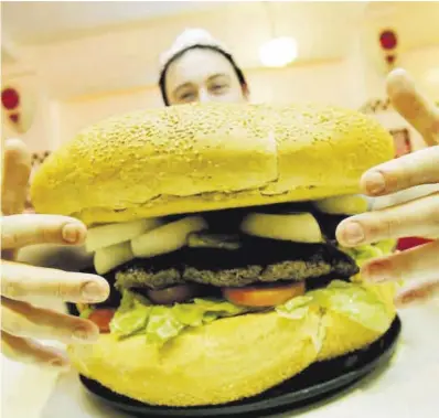 ?? Efe / Epa / Cathal McNaughton ?? Un cliente se dispone a comer una hamburgues­a gigante en un restaurant­e de comida rápida.