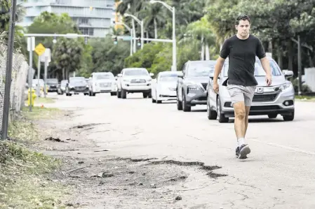  ?? AL DIAZ adiaz@miamiheral­d.com ?? A pedestrian walking in Miami’s Coconut Grove.