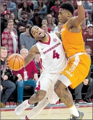  ?? NWA Democrat-Gazette/CHARLIE KAIJO ?? Guard Daryl Macon (4) tries to drive to the basket past forward Admiral Schofield during Arkansas’ victory over Tennessee on Saturday. Macon scored a career-high 33 points.