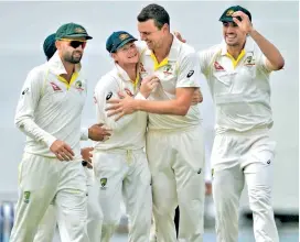  ?? — AP ?? Australian players celebrate a wicket during the third Ashes Test against England at Perth on Monday.