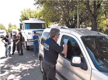  ??  ?? Peritaje. Especialis­tas de la fuerza de seguridad revisan el vehículo de los cómplices.