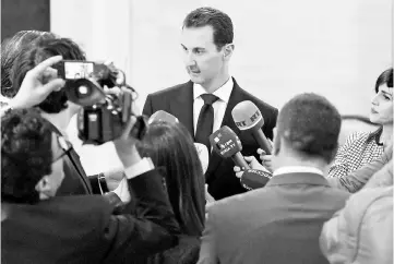  ??  ?? Assad (centre) speaking to the press after receiving a Russian delegation in Damascus. — AFP photo