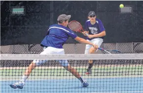  ?? JIM THOMPSON/JOURNAL ?? La Cueva’s Julian Lee, foreground, backhands a return while teammate Kyler Kunzler converges in their doubles victory Saturday, helping the Bears win the Class 6A team title.