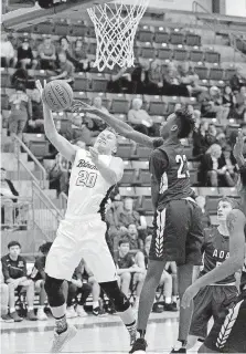  ?? [PHOTO BY SARAH PHIPPS, THE OKLAHOMAN] ?? Blanchard’s McCale Bailey goes up for a lay up as Ada’s Jaxson Robinson defends during the boys high school basketball game between Blanchard and Ada at Newscastle High School on Thursday.