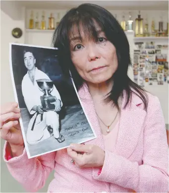  ?? TONY CALDWELL ?? Tina Takahashi holds a photo of her late father Mas Takahashi. Her family had scheduled a celebratio­n of life for April 5, but has postponed the event because of travel and attendance-number complicati­ons related to the COVID-19 outbreak.