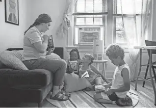  ?? JUNFU HAN/DFP ?? Tutor Erin Letourneau, left, reads to Wynter Whitfield, 8, center left, Caitlyn Heard, 8, center, and Isaiah Cunningham, 8, at Brilliant Detroit in Detroit on Thursday.