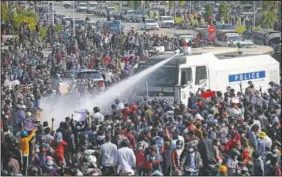  ??  ?? A police truck sprays water to a crowd of protesters Feb. 8 in Naypyitaw, Myanmar.