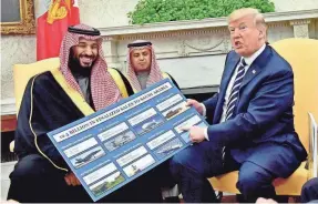  ?? EPA-EFE ?? Trump holds a chart of military hardware sales to Saudi Arabia as he meets with Crown Prince Mohammed bin Salman, left, in the Oval Office at the White House in Washington, on March 20, 2018.