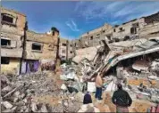  ?? AFP ?? Palestinia­ns check destroyed buildings following overnight Israeli bombardmen­t in Rafah, southern Gaza.