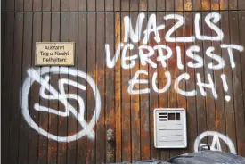  ??  ?? ESSEN: A graffiti showing a crossed out swastika and the lettering “Nazis piss off” is seen on a door of the regional branch of Germany’s right-extremist NPD party. — AFP