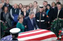  ?? The Canadian Press ?? Former President George W. Bush and former first lady Laura Bush pause in front of the flag-draped casket of former President George H.W. Bush as he lies in state in the Capitol’s Rotunda in Washington.