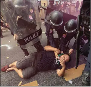  ?? (AP/Wason Wanichakor­n) ?? Police officers remove a protester who was trying to march to the site of the Asia-Pacific Economic Cooperatio­n summit Friday in Bangkok. Several hundred protesters were attempting to present a letter stating their concerns but were blocked by the police. A clash ensued and officers charged the crowd.