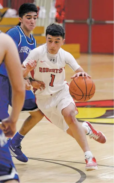  ?? LUIS SÁNCHEZ SATURNO/THE NEW MEXICAN ?? Robertson’s Lubby Marrujo drives against St. Michael’s players Friday in Michael Marr Gymnasium in Las Vegas, N.M. He helped extend the Cardinals’ 20-point lead late in the second quarter.