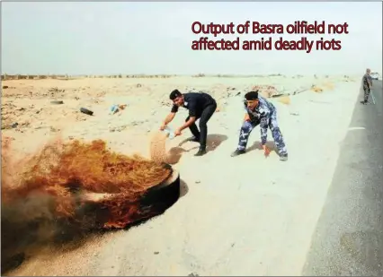  ?? PICTURE: REUTERS/ESSAM AL-SUDANI ?? Iraqi police officers throw sand to put out fires that protesters set ablaze during a protest at the main entrance to the giant Zubair oilfield near Basra, Iraq.