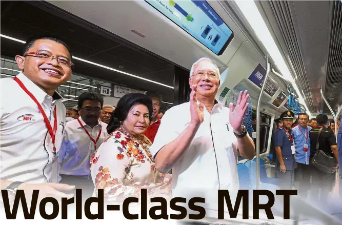  ??  ?? Well done: Najib showing his delight as he boards a train at the TRX station. Accompanyi­ng him are his wife Datin Seri Rosmah Mansor, Finance Minister II Datuk Seri Johari Abdul Ghani (second from left) and MRT Corp CEO Datuk Seri Shahril Mokhtar (left). Looking on is Transport Minister Datuk Seri Liow Tiong Lai (second right). Picture below shows a train plying the Sungai Buloh-Kajang Line.