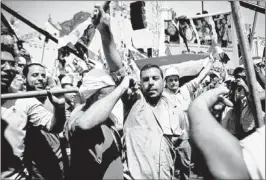  ?? VIRGINIE NGUYEN HOANG/ASSOCIATED PRESS ?? Men chant and dance with sticks and national flags at a rally to support Egyptian President Mohammed Morsi in Cairo on Sunday. Thousands of opponents and supporters of Egypt’s Islamist president gathered in city squares in competing rallies Sunday.