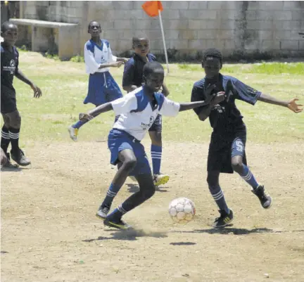  ?? (Photo: Paul Reid) ?? Flankers Primary’s Delgado Irving (left, foreground) and Barrett Town Primary’s Kerome Edwards battle for the ball in their St James FA Under-13 football competitio­n at Corinaldi Avenue Primary last week. Delgado scored in the game that Flankers Primary won 6-0.