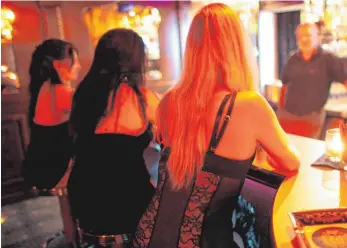  ?? FOTO: DPA ?? Frauen sitzen in einem Kölner Bordell an einer Bar. Aber auch die Stadt Ravensburg ist groß genug, um Prostituti­on zulassen zu müssen. Wo, regelt die Sperrbezir­ksverordnu­ng, an der seit Jahren gearbeitet wird.