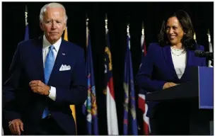  ?? (AP/Carolyn Kaster) ?? Joe Biden collects his mask from the lectern Wednesday before Kamala Harris speaks at Alexis duPont High School in Wilmington, Del. “This is a moment of real consequenc­e for America. Everything we care about — our economy, our health, our children, the kind of country we live in — it’s all on the line,” Harris said. More photos at arkansason­line.com/813harris/.