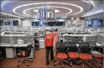  ?? KIN CHEUNG / AP ?? Yip Wing-keung, a trading manager at local brokerage Christfund Securities, wears his red trading jacket as he walks at the Hong Kong Stock Exchange. Hong Kong’s last stock exchange is preparing to shut its trading hall, going fully automated.