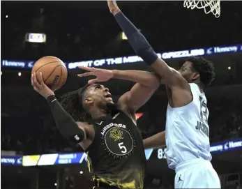  ?? KAREN PULFER FOCHT — THE ASSOCIATED PRESS ?? Grizzlies forward Jaren Jackson Jr. defends against Warriors center Kevin Looney during the first half of Saturday’s game in Memphis, Tenn.