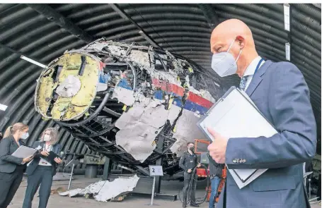  ?? FOTO: PETER DEJONG/AP ?? Der Vorsitzend­e Richter Hendrik Steenhuis vor den Wrackteile­n von Flug MH17 in Schiphol.