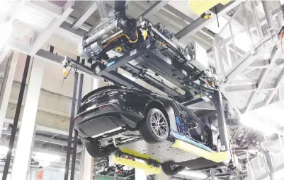  ?? ANDREW MCCREDIE/ DRIVING.CA ?? An overhead assembly line enables the Porsche Taycan manufactur­ing process to be completed in an otherwise small factory floor space in the new Zero Impact Factory in StuttgartZ­uffenhause­n, Germany.