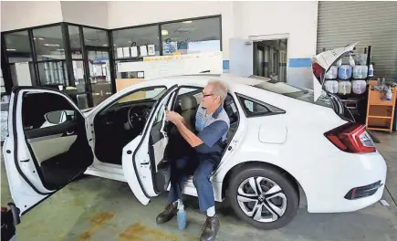  ?? RYLEE SMITH / MILWAUKEE JOURNAL SENTINEL ?? Craig Koenings from Russ Darrow Honda details a 2017 Honda Civic at the dealership, 9301 W. Brown Deer Road, in Brown Deer on Monday. Car dealership­s are worried about the threat of a 25 percent tariff on imported cars, plus tariffs on thousands of automotive parts.