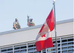  ?? AP ?? Canadian soldiers stand guard on the rooftop of their embassy in Portau-Prince, Haiti, on Wednesday, April 10.