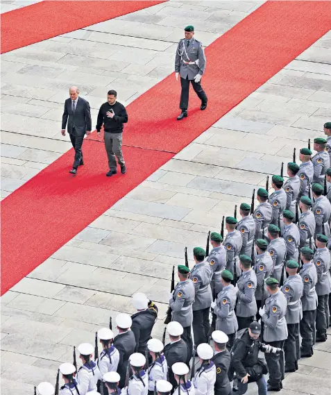  ?? ?? German Chancellor Olaf Scholz and Ukraine’s President Volodymyr Zelensky inspect a Bundeswehr honour guard at the Chanceller­y in Berlin yesterday