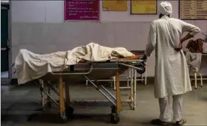  ?? DANISH SIDDIQUI/REUTERS ?? A man stands next to the body of his wife inside an emergency ward of a hospital in Uttar Pradesh, India, on May 11, 2021.