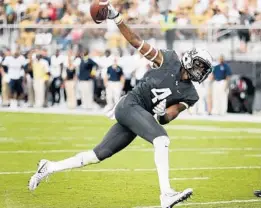  ?? STEPHEN M. DOWELL/STAFF PHOTOGRAPH­ER ?? UCF wide receiver Tre’Quan Smith leaps into the end zone to finish a 50-yard touchdown catch during the season opener against FIU at Spectrum Stadium.