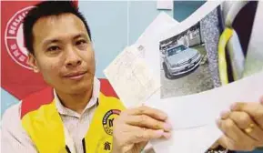  ?? PIC BY MUHAMMAD MIKAIL ONG ?? Malaysian United Party youth secretary Ong Chun Jiet showing a picture of his car. He called on the Penang Island City Council to take responsibi­lity for his scratched vehicle at the party office in Lebuh Melaka, George Town, yesterday.
