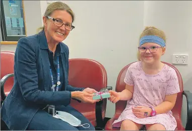  ?? ?? THANK YOU: Royal Victorian Eye and Ear Hospital speech pathologis­t Denise Courtney accepts a donation from Katie Schumann for the cochlear implant clinic.