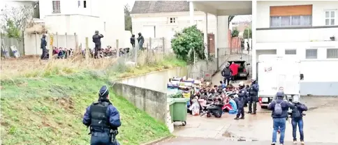  ??  ?? Students sit on the ground after being arrested by police in the garden of a pavilion and an associated house close at the Saint-Exupery high school in Mantes-la-Jolie in the Yvelines, following clashes in which 146 people were arrested. — AFP photos