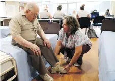  ??  ?? PSW Valerie Little helps George Vuillard at the Perley Rideau in Ottawa. It’s a difficult job, mentally and physically, says Little. But she enjoys it.