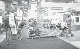  ?? Marie D. De Jesus / Houston Chronicle ?? Workers carry away ladders to take apart the infrastruc­ture of the Offshore Technology Conference on its last day. Some vendors say business might pick up next year.