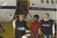  ?? (Italian Police/Reuters) ?? MEDHANIE YEHDEGO MERED is seen with police after landing at Palermo’s airport early yesterday.