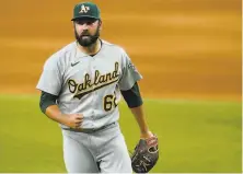  ?? Tony Gutierrez / Associated Press ?? A’s relief pitcher Lou Trivino celebrates after striking out Eli White to end the ninth and send the game to extra innings.