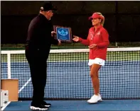  ??  ?? Lodi High girls tennis head coach Shebly Stillwell accepts the runner-up trophy from Sac-Joaquin Section official Brian Moore after Thursday’s match.