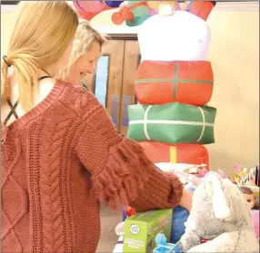  ?? ?? Makenna Keene, left, and Jennifer Harvey, right, look over some of the thousands of toys and gifts set out Saturday at The Ridge Church.